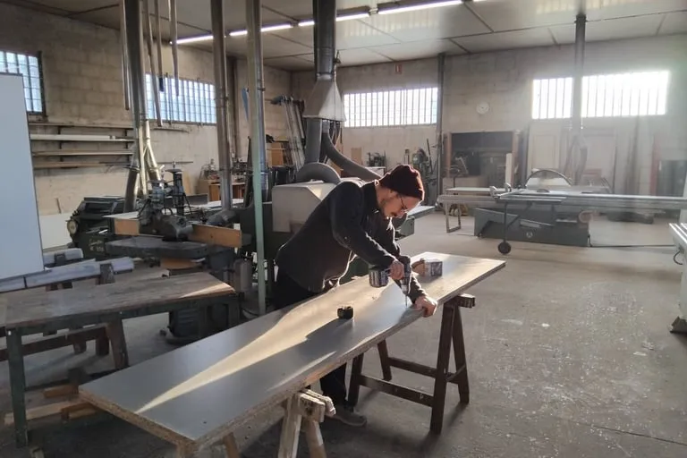 Artisan opérant une scie à format dans un atelier de menuiserie